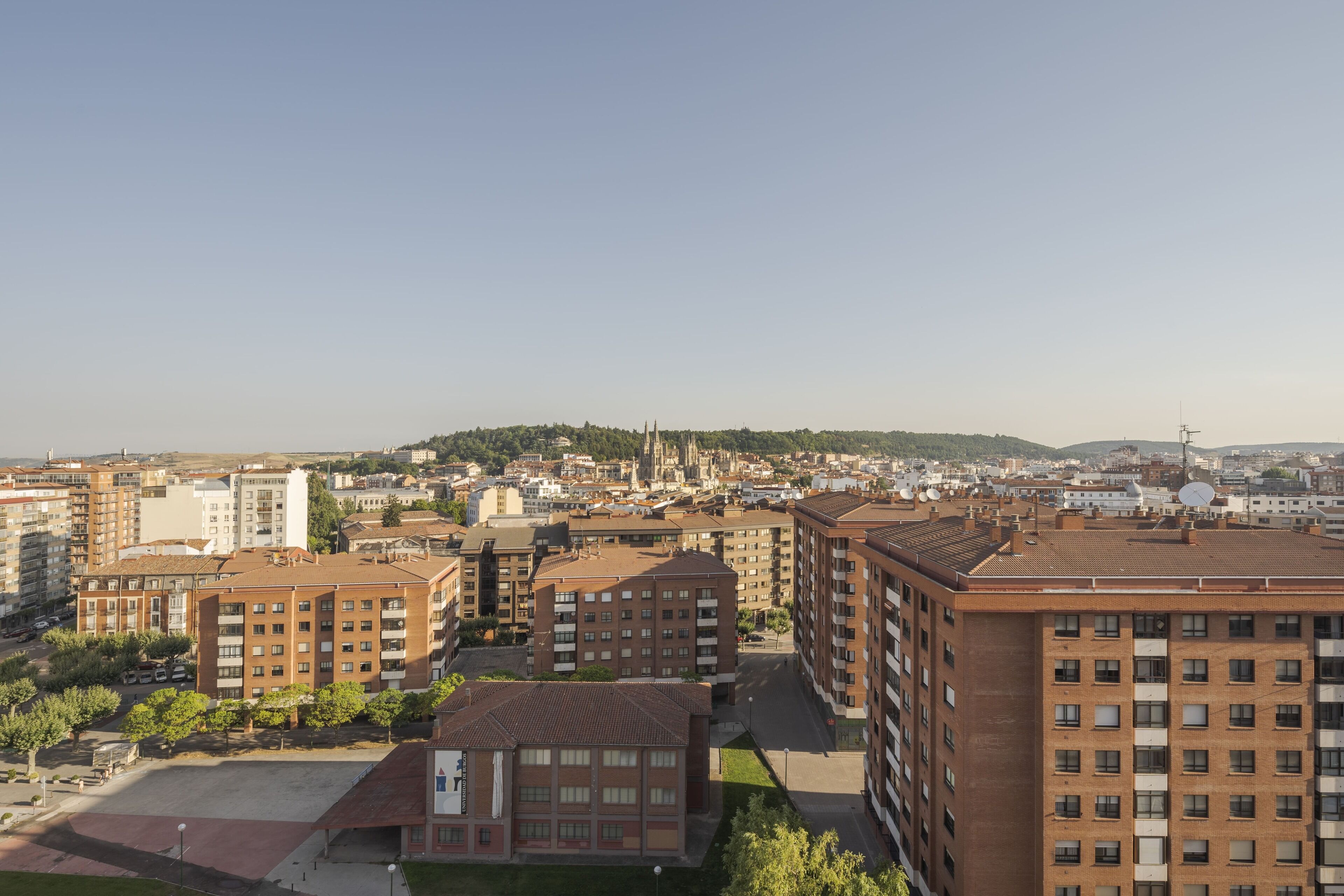 Een hoog appartementencomplex met meerdere balkons en een binnentuin.