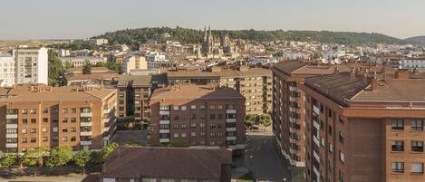 Um edifício alto com vários andares, um pátio e vista para um horizonte urbano distante.