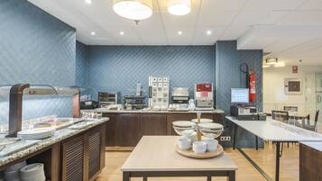 Un'area cucina moderna con un angolo buffet, inclusa una postazione caffè e diversi elettrodomestici.
