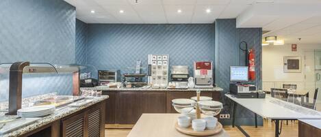 A modern kitchen area with a buffet setup, including a coffee station and various appliances.