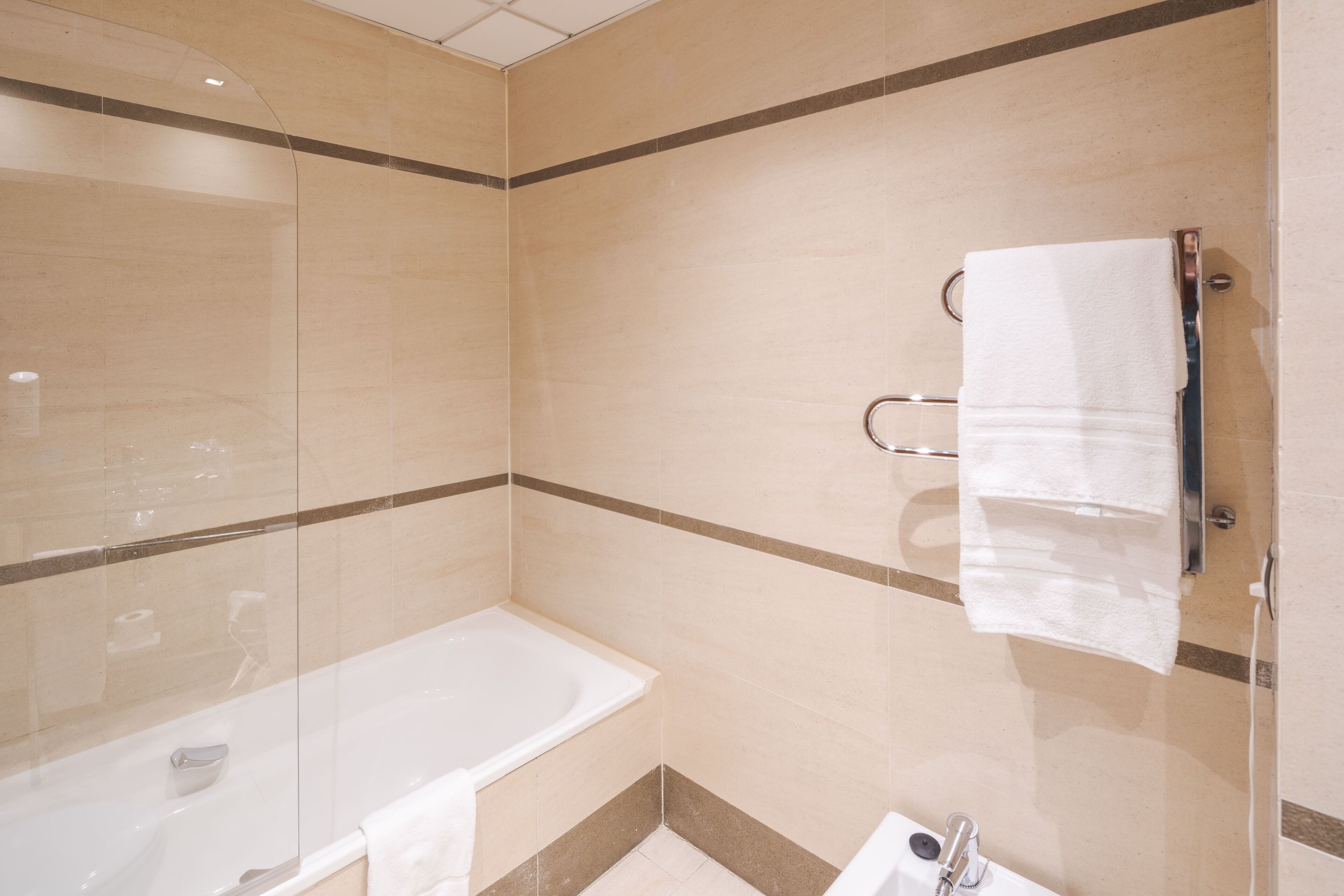 A modern bathroom with a glass shower enclosure, a bathtub, and a toilet.
