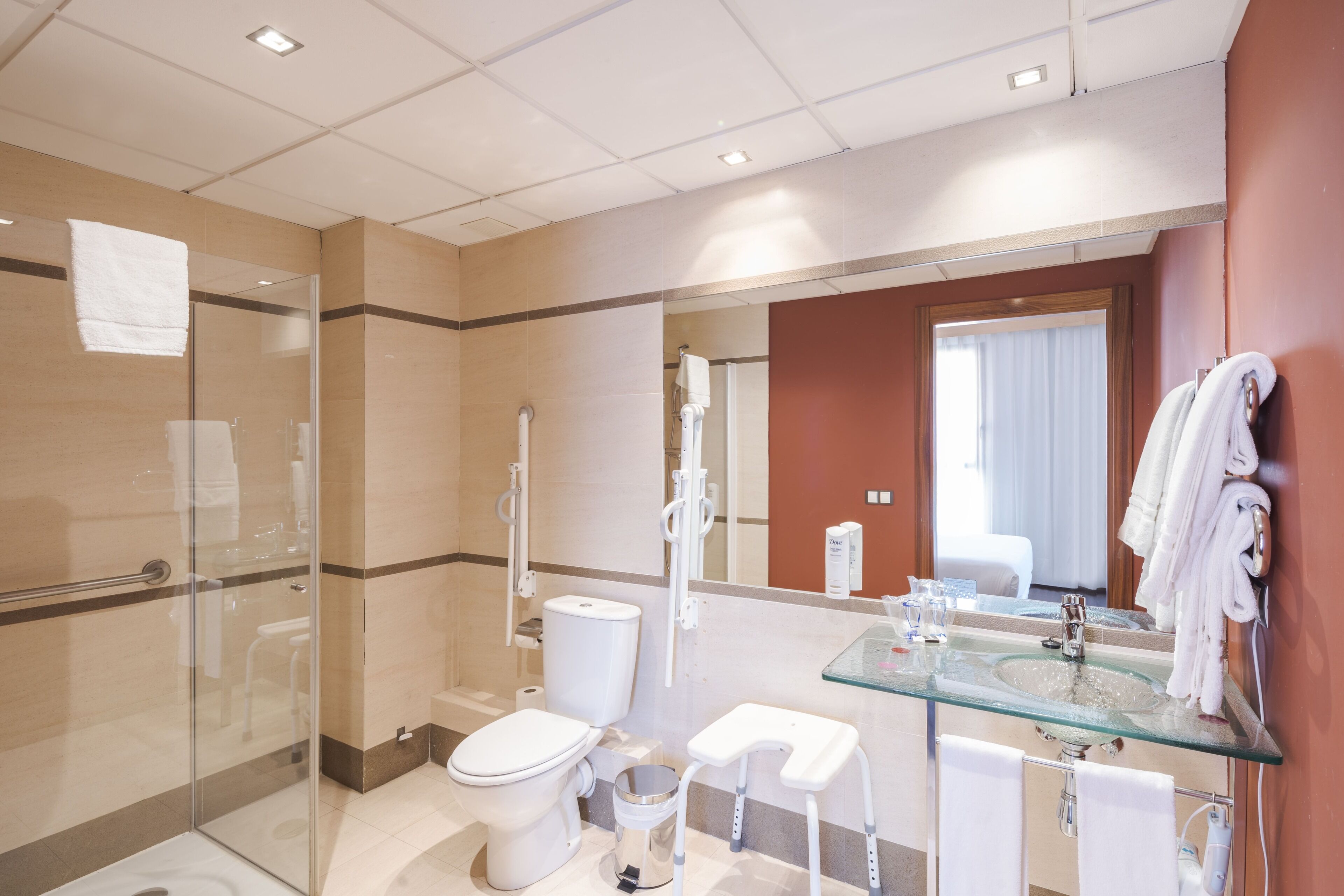 Ein modernes Badezimmer mit Duschkabine aus Glas, Waschbecken aus Glas und Toilette.