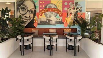 Un intérieur moderne agrémenté d’une fresque murale, d’un espace salon et de plantes.