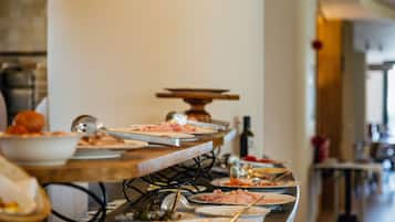 A buffet setup with various dishes and utensils.