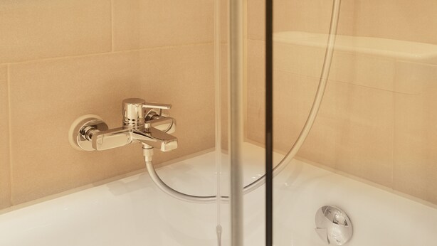 Une salle de bain moderne avec une douche à parois de verre, un robinet chromé et des toilettes.