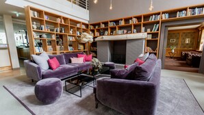 A modern living room with a purple sofa set, a coffee table, and a fireplace.