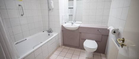 Un baño con bañera, lavabo e inodoro.