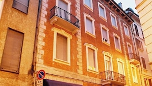 A multi-story building with a ground-floor restaurant featuring awnings and a no-parking sign. - Genius Hotel Downtown (Milan)