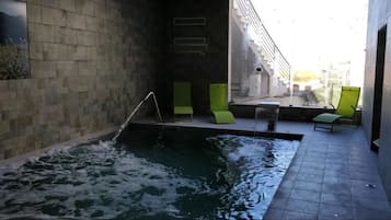Una piscina cubierta, una piscina al aire libre, sombrillas, tumbonas