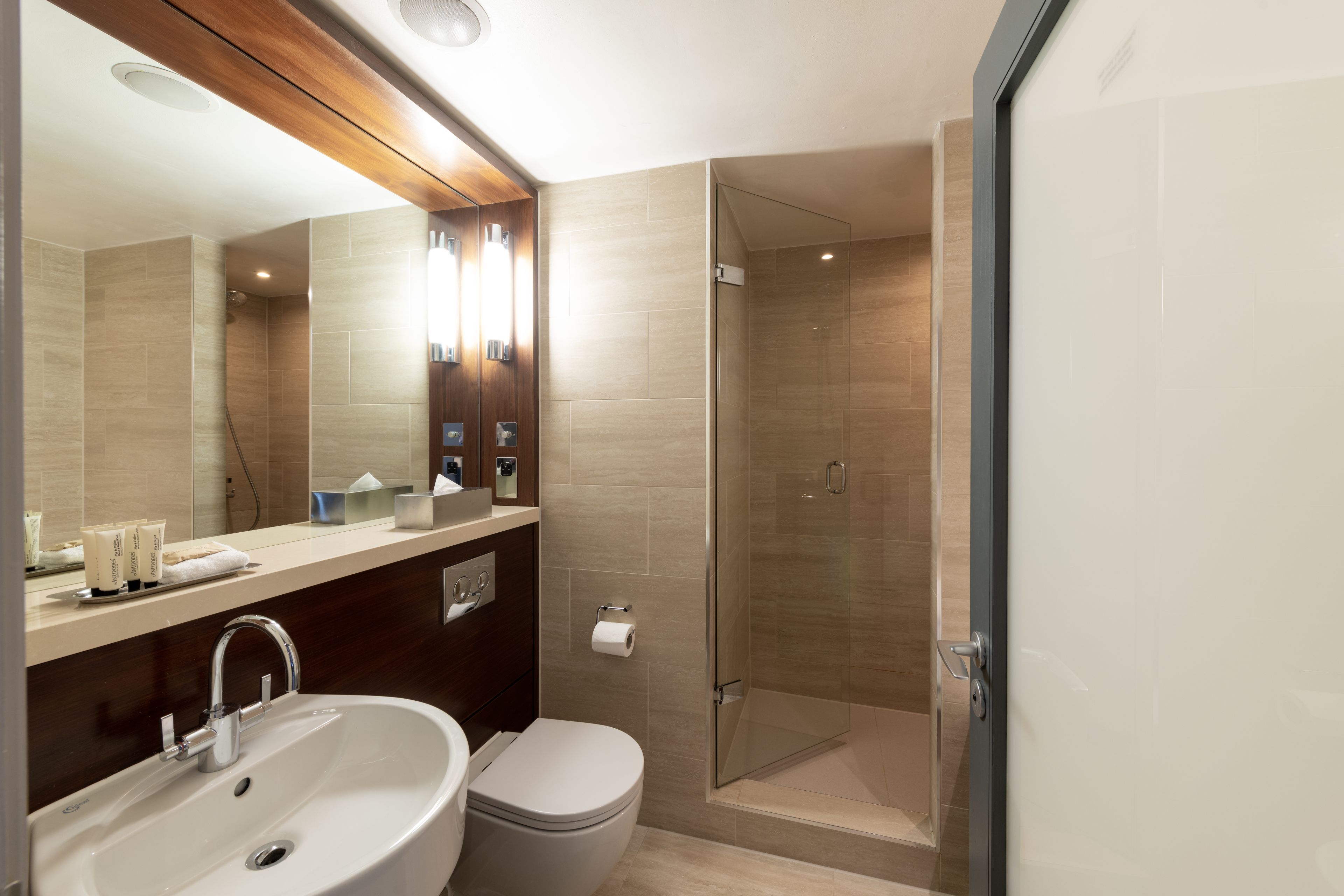 A modern bathroom with a sink, toilet, and glass-enclosed shower.
