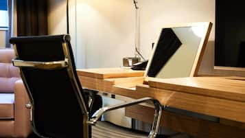 A modern office desk with a laptop, a chair, and a lamp.