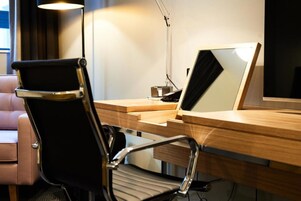 Un escritorio moderno con una computadora portátil, una silla y una lámpara.