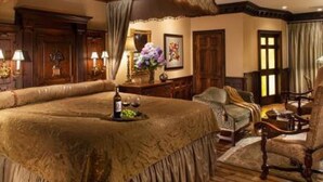 Ein geräumiges Zimmer mit einem großen Bett, Holzmöbeln und klassischer Einrichtung.