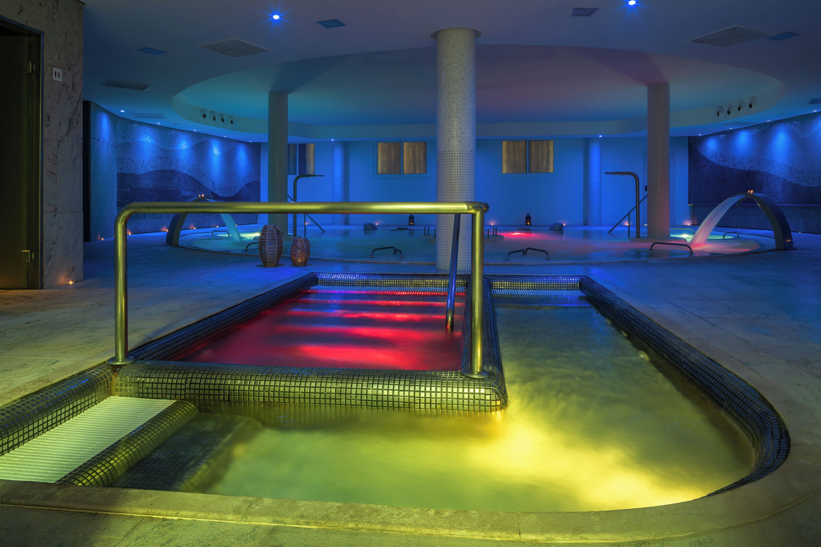 A spa area with a hot tub, a massage chair, and a water feature.