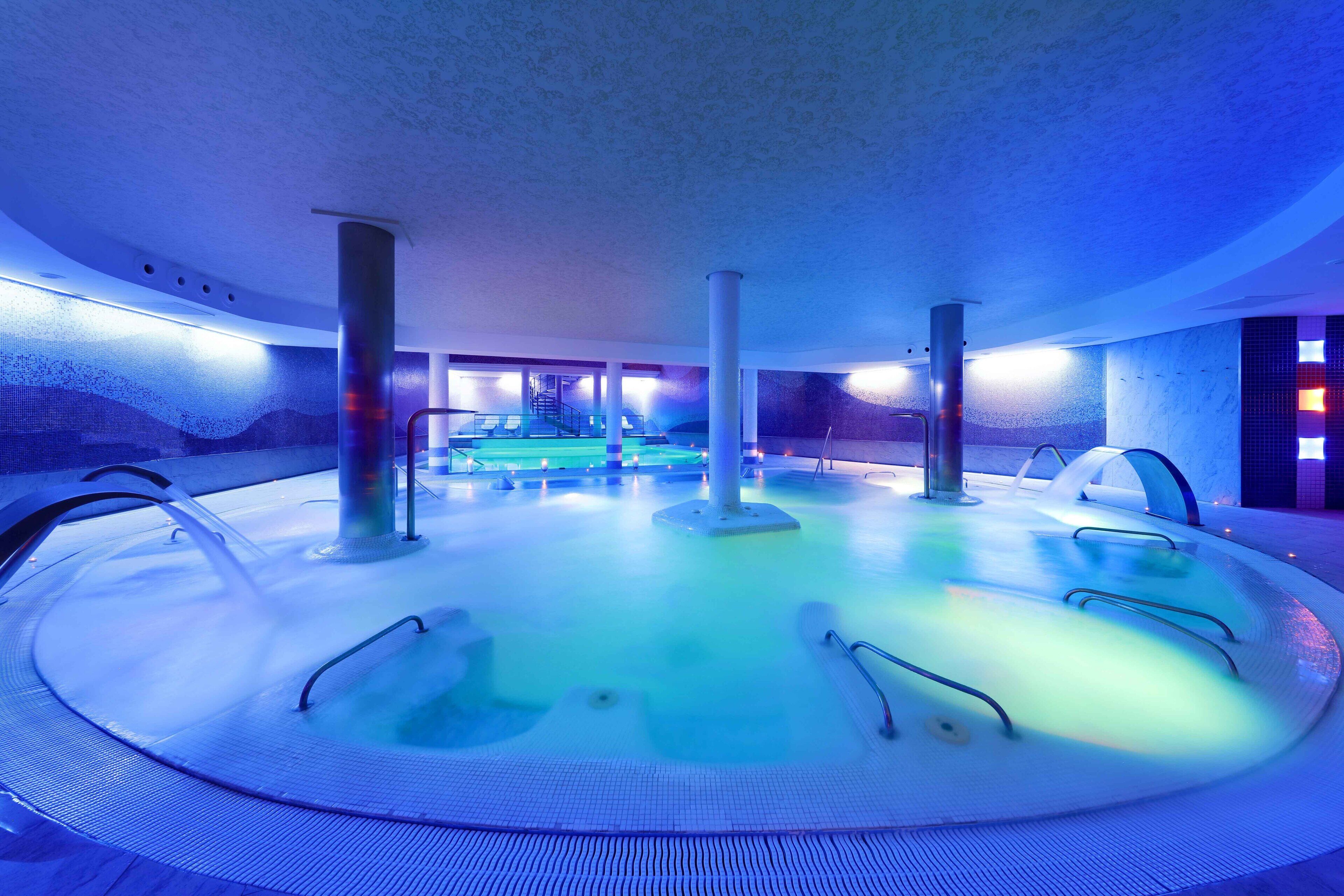 A circular hot tub area with multiple seating options and a central water feature.