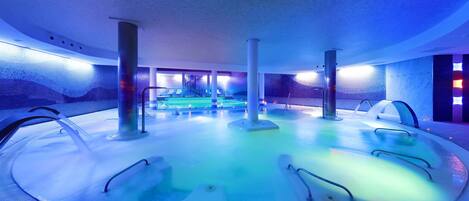 A circular hot tub area with multiple seating options and a central water feature.