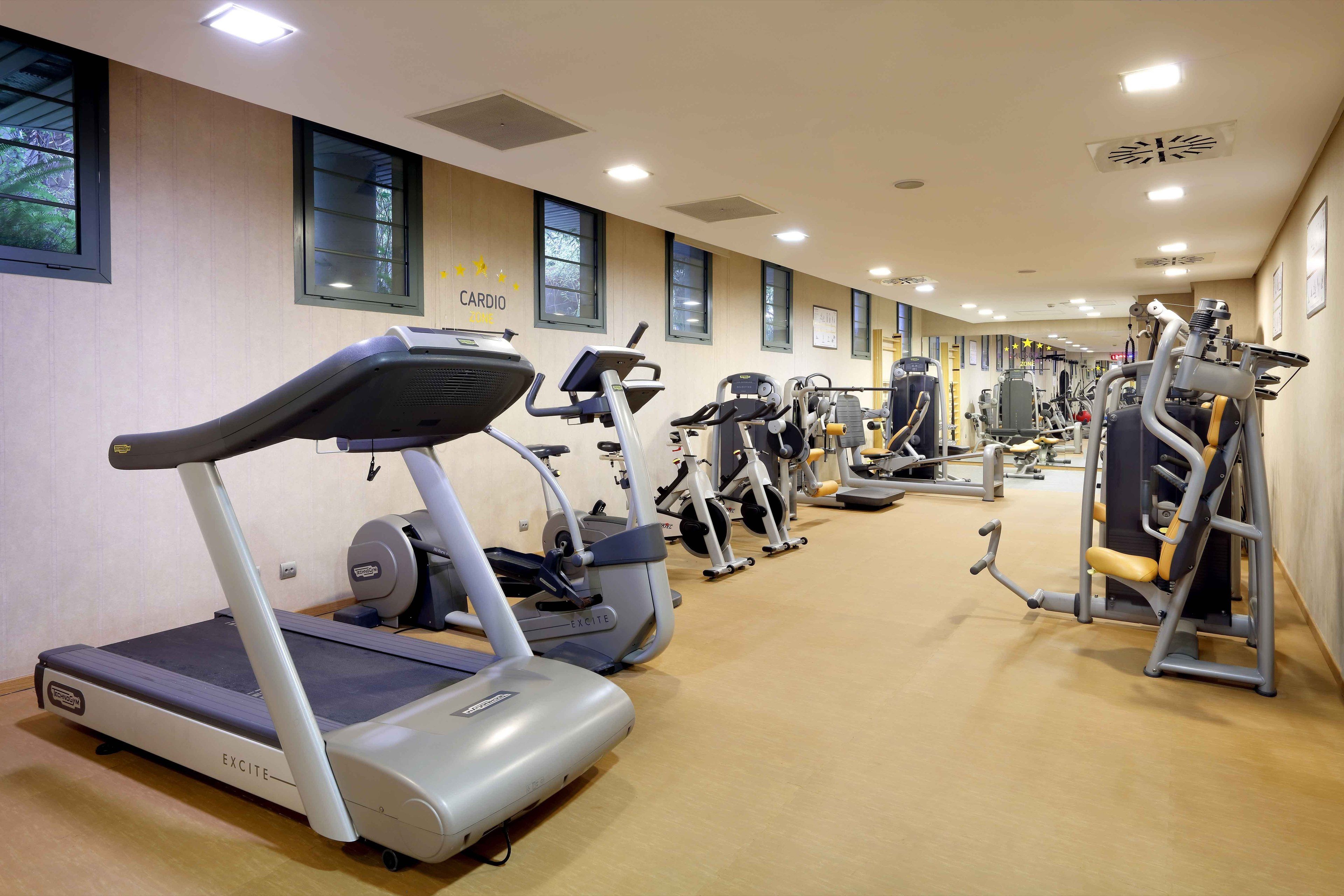 A gym with cardio equipment, weight machines, and a variety of exercise machines.