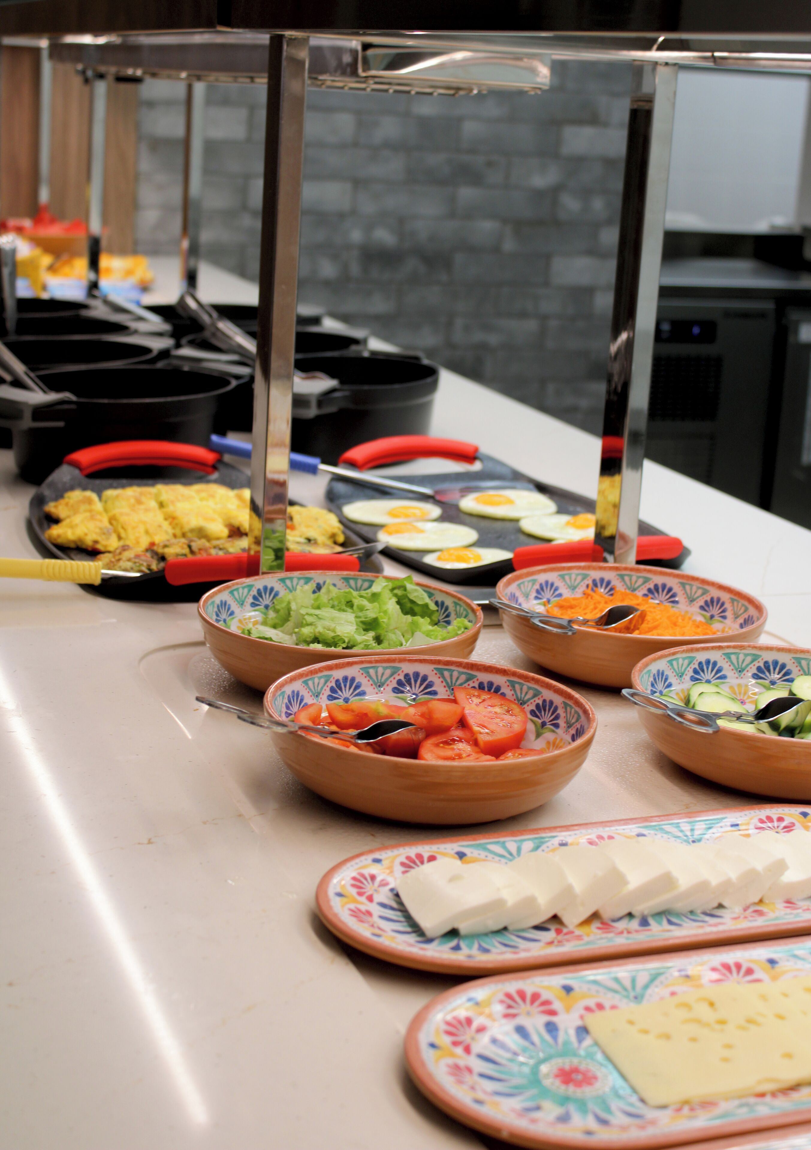 Ein reichhaltiges Buffet mit verschiedenen Speisen, darunter Salate, Eier und Käse.
