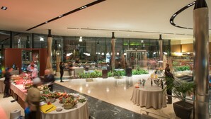 Un vaste espace intérieur doté de nombreuses tables et chaises, de cloisons en verre et d’une colonne centrale.