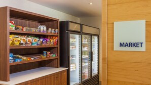 A market area with shelves stocked with snacks and a refrigerated display case. - Holiday Inn Express Saint John Harbour Side by IHG (Saint John)