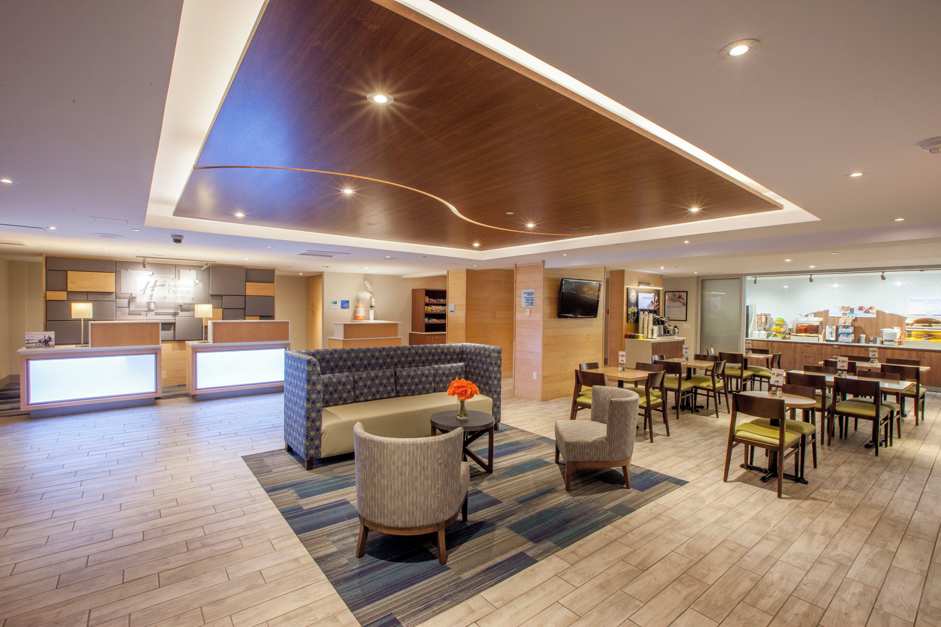 Un vestíbulo de hotel con mostrador de recepción, área de estar y comedor.