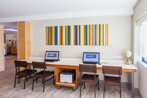 A modern office space with two desks, four chairs, and a large abstract painting on the wall. - Holiday Inn Express Saint John Harbour Side by IHG (Saint John)