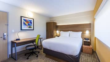 Une chambre d’hôtel équipée d’un lit, d’un bureau, d’une chaise et d’une table de chevet.