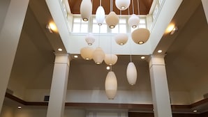 A spacious atrium with multiple hanging pendant lights and a central display. - Hilton Garden Inn Oxnard/Camarillo (Oxnard)