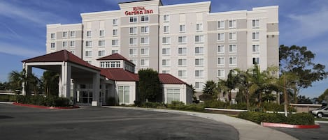 A Hilton Garden Inn hotel with a modern design, featuring a large parking lot and a covered entrance.
