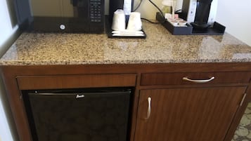 A kitchen with a GE microwave, a Keurig coffee maker, and a refrigerator.