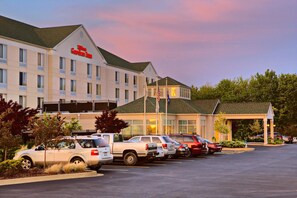 A hotel with a garden inn sign, multiple parking spaces, and a covered entrance. - Hilton Garden Inn Springfield, IL. (Springfield)