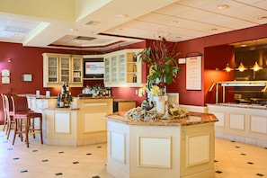 A hotel restaurant with a bar area, seating, and a menu board. - Hilton Garden Inn Springfield, IL. (Springfield)