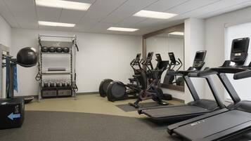 A gym with treadmills, elliptical machines, and weightlifting equipment.