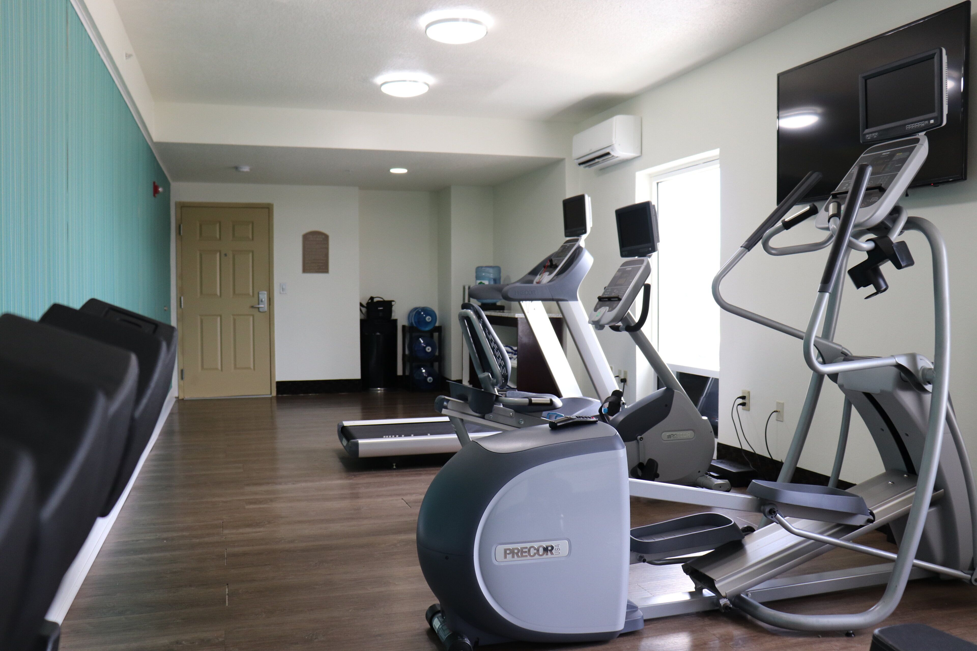 A gym with treadmills, elliptical machines, and a stationary bike.