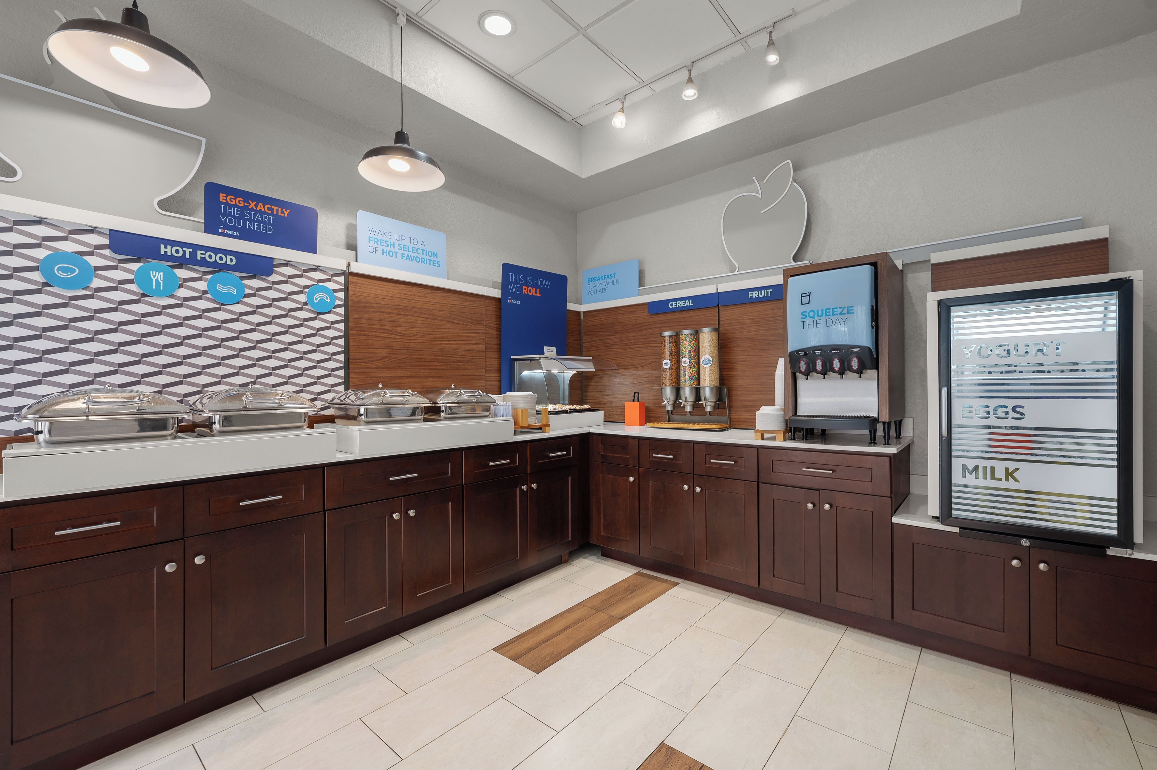 A modern breakfast bar with a variety of food options, including a refrigerated display for dairy products.