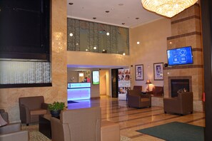 A lobby with a reception desk, seating area, and a fireplace. - Holiday Inn Hazlet by IHG (Hazlet)