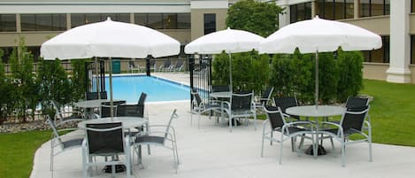 Een buitenzwembad, parasols voor strand/zwembad