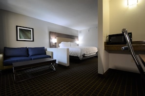 A hotel room with a bed, a sofa, a desk, and a microwave. - Holiday Inn Hazlet by IHG (Hazlet)