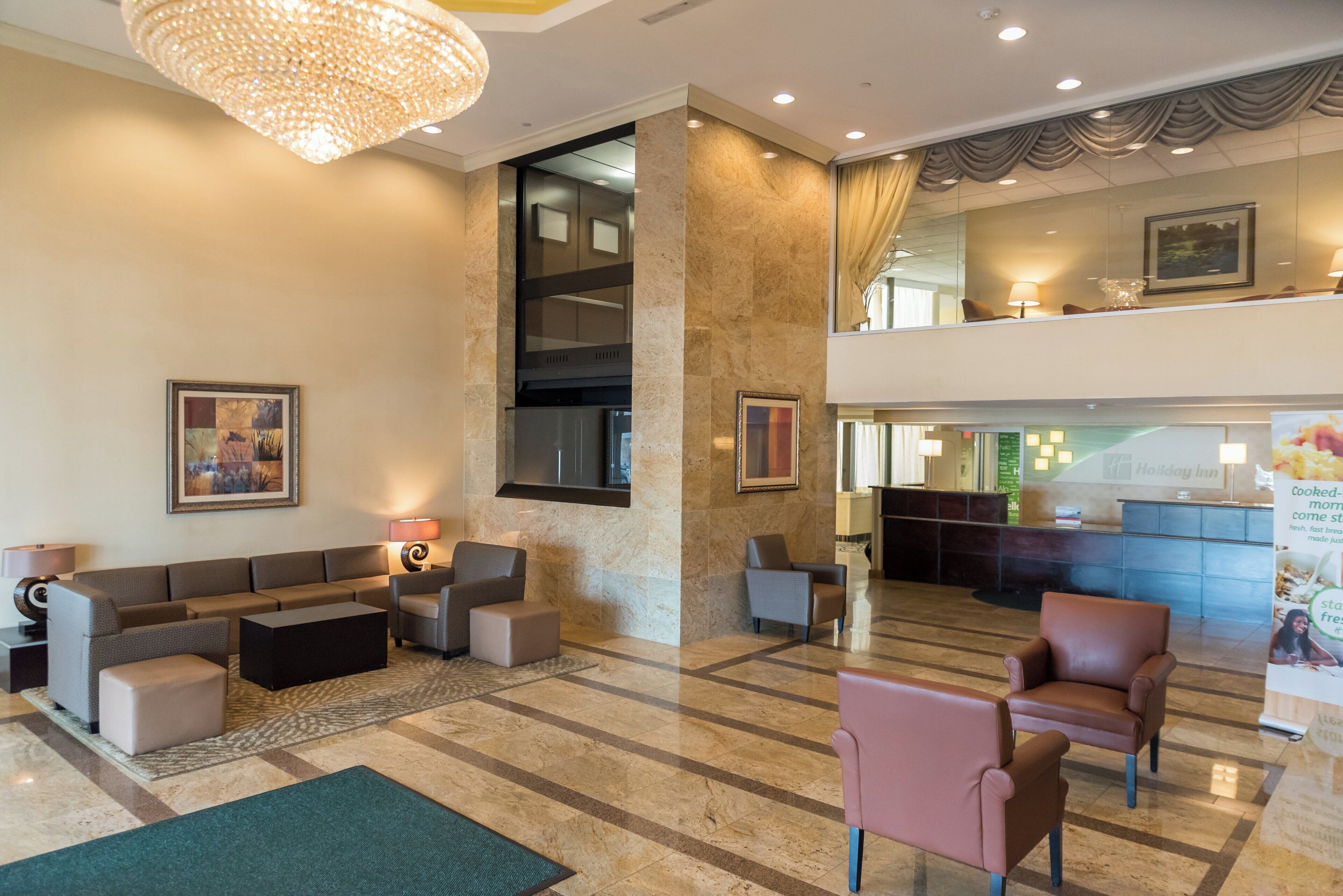 Eine Hotelhalle mit Sitzgelegenheiten, einem Kronleuchter und einer Rezeption.