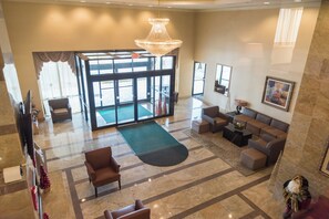 A hotel lobby with a chandelier, seating area, and a large glass door entrance. - Holiday Inn Hazlet by IHG (Hazlet)