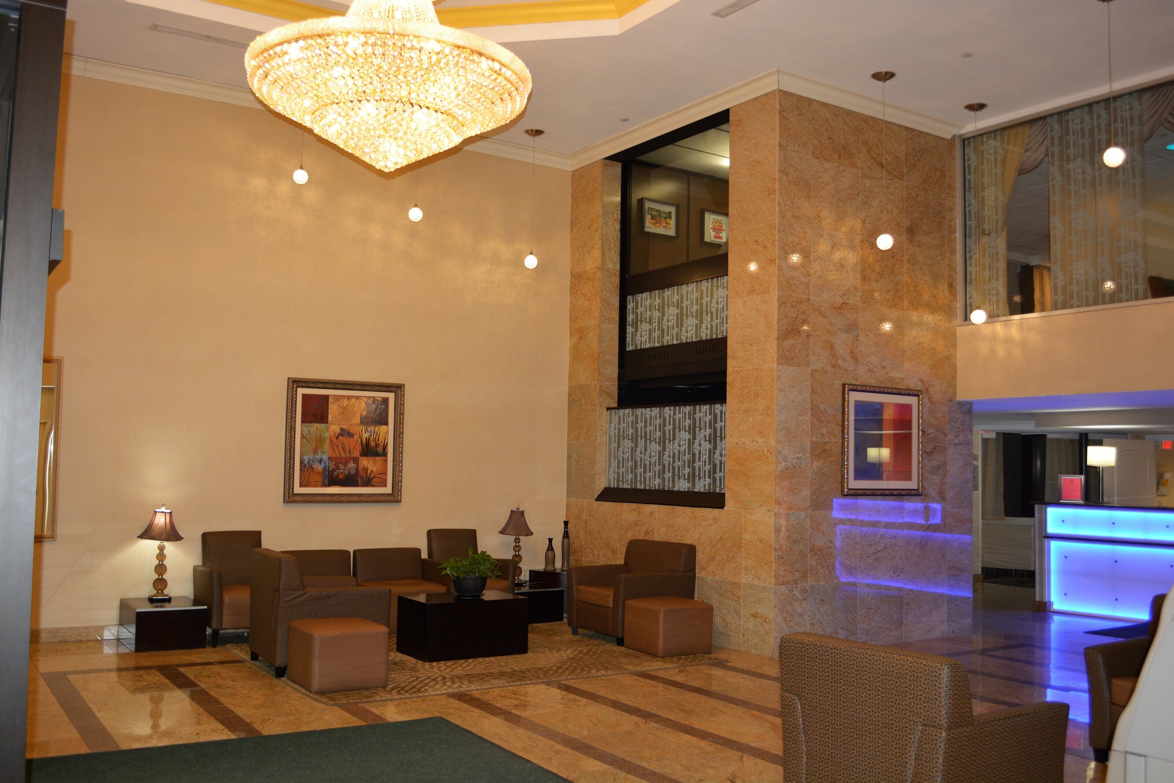 A lobby with seating, a chandelier, and a reception desk.