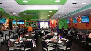 A restaurant with multiple tables and chairs, a bar area, and several televisions on the walls. - Holiday Inn Hazlet by IHG (Hazlet)