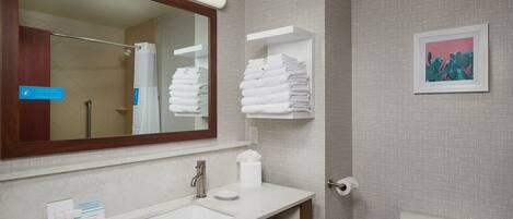 A bathroom with a white sink, mirror, and towel rack.