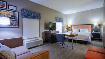 A hotel room with a bed, desk, chair, and a television.