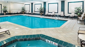 An indoor swimming pool with a 3 FT depth marker, lounge chairs, and potted plants. - Hampton Inn Littleton (Littleton)