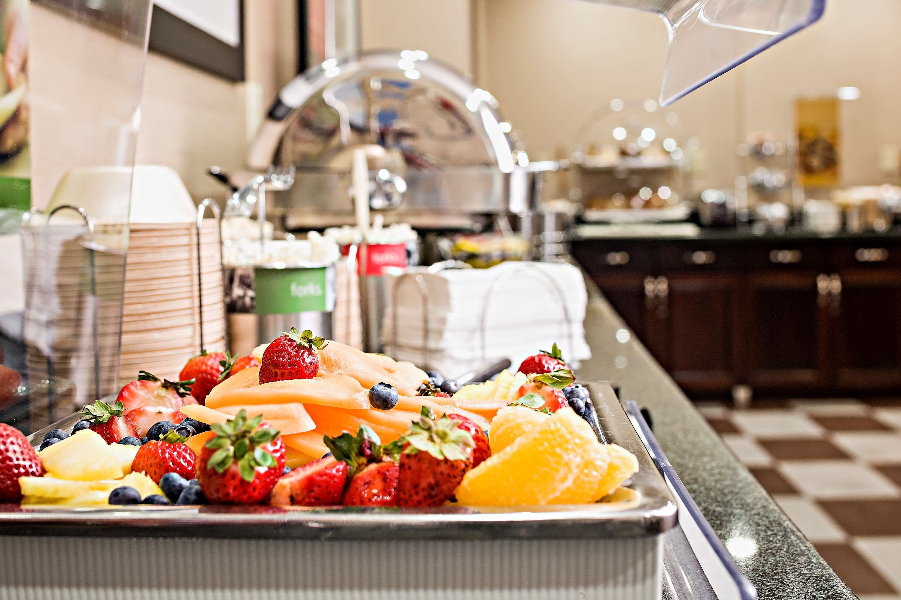 Un buffet proposant une variété de fruits, notamment des fraises, des myrtilles et des melons.