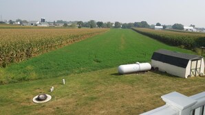 A rural landscape with a field, a small shed, and a cylindrical tank. - Scottish Inn Ronks (Ronks)