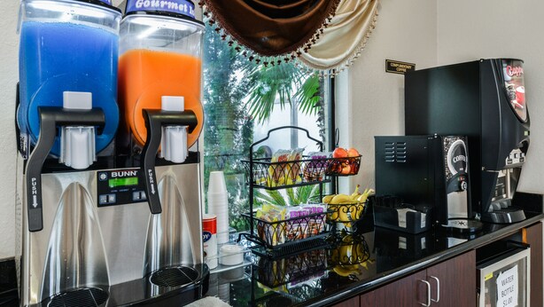 Ein Kaffee-Bereich mit zwei Getränkespendern, einer Kaffeemaschine und einer Snack-Auslage.