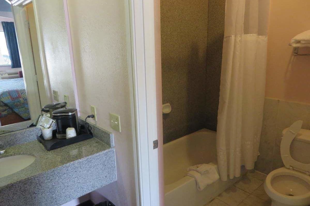 Une salle de bain avec douche, toilettes et lavabo.