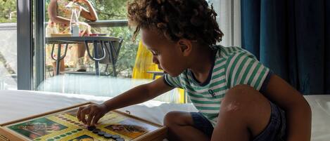 Un niño jugando con un juego de mesa de madera sobre una cama.